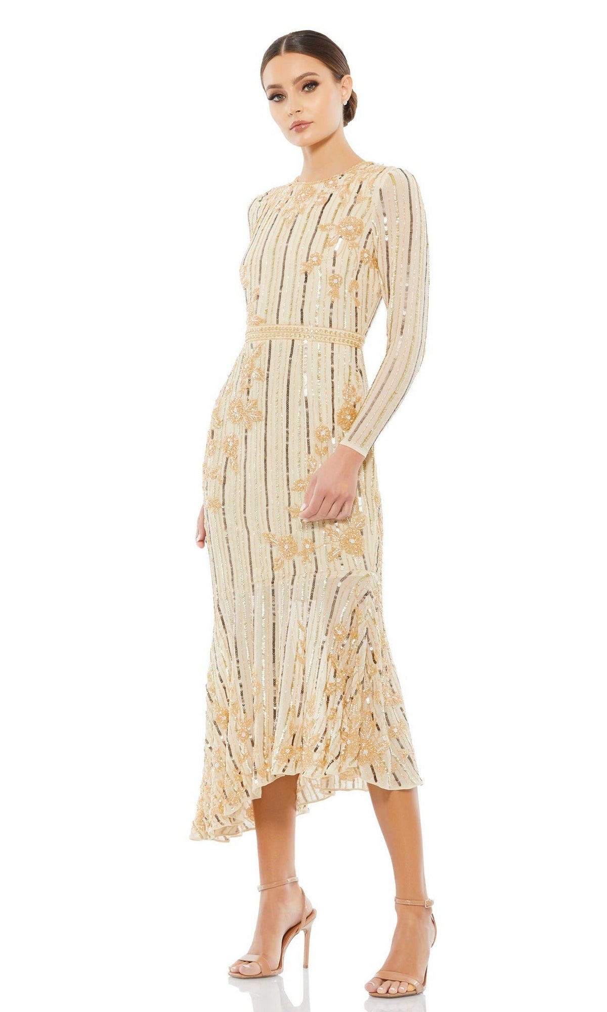 Woman in a beige Mac Duggal 93627 midi sequin wedding guest dress with gold accents and strappy nude heels, posing against a white background.